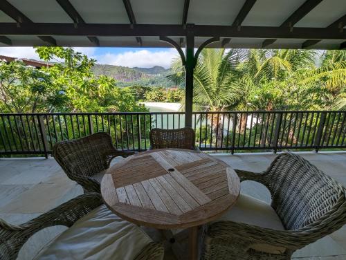 a wooden table and two chairs on a balcony at Maison La Plage by Simply-Seychelles in Eden Island