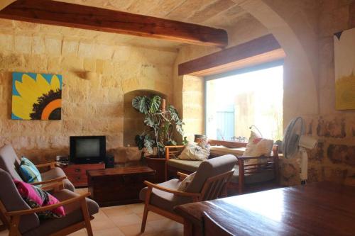 un salon avec un canapé et une télévision dans l'établissement Bebbux Farmhouse, à Munxar