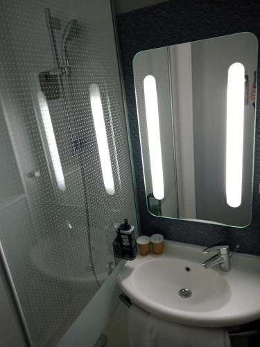 a bathroom with a sink and a mirror at ibis Orange Centre in Orange