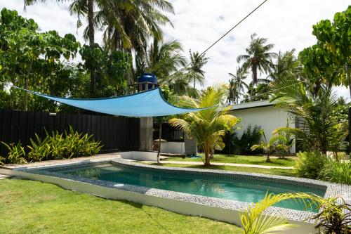 a hammock hanging over a swimming pool in a yard at Amara Pool & Villas 180Mbps Central location in General Luna