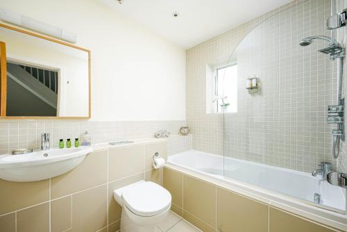 ein Badezimmer mit einer Badewanne, einem WC und einem Waschbecken in der Unterkunft Falcon House CW73 Lower Mill Estate Cotswolds in Somerford Keynes