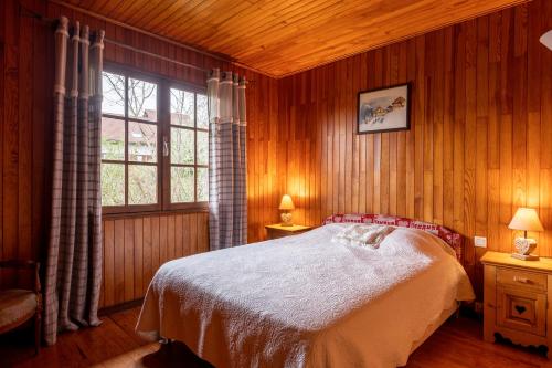 ein Schlafzimmer mit einem großen Bett und einem Fenster in der Unterkunft Chalet de Charme avec vue spendide in Menthon-Saint-Bernard