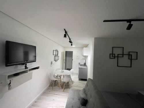 een woonkamer met een bank en een tv aan de muur bij Ap91 Sky Paulicéia in Sao Paulo