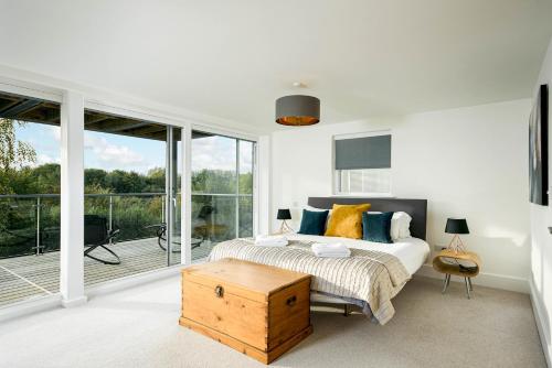 a bedroom with a bed and a large window at Shelducks HM119 Lower Mill Estate The Cotswolds in Somerford Keynes