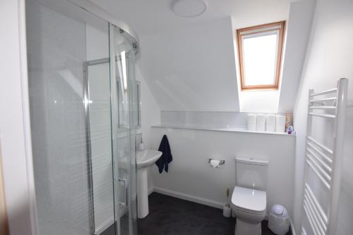 a bathroom with a shower and a toilet and a sink at Moray Cottages in Dufftown