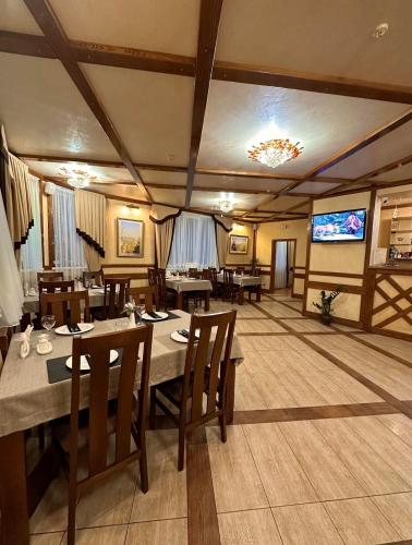 a dining room with tables and a large screen at База відпочинку ШИПОВЕЦЬ in Poroškov