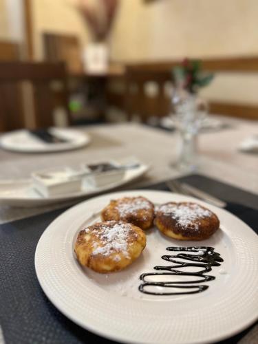 two donuts on a white plate on a table at База відпочинку ШИПОВЕЦЬ in Poroškov