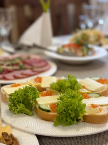 a table topped with plates of sandwiches with lettuce at База відпочинку ШИПОВЕЦЬ in Poroškov