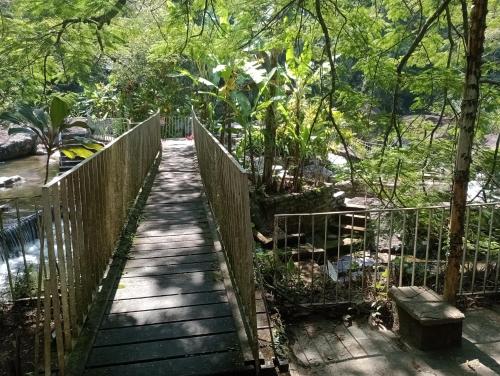 a wooden walkway in a park with a fence at Conora hotel in Itatiaia