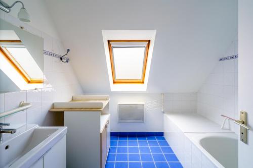 een badkamer met een wastafel, een bad en een raam bij Ti Louarn - Maison à 2 km de la plage in Fouesnant
