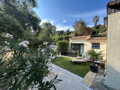 a garden with a bench and a house at Petit Havre de Paix avec Jacuzzi Luxe & Jardin Privatif Zen in Cavalaire-sur-Mer