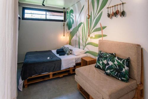 a small bedroom with a bed and a chair at Econtainer Ubatuba in Ubatuba