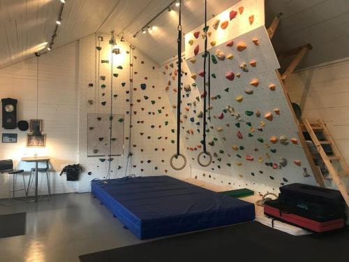 a room with a rock climbing wall with a bed at Fiskebäckgårds gästhus in Lysekil