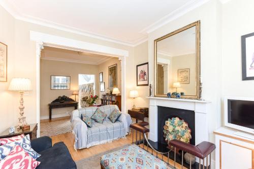 a living room with a fireplace and a mirror at Ivy Glendarvon Street Pro-Managed in London