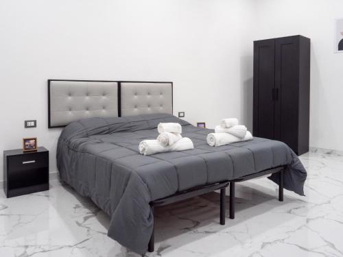 1 dormitorio con 1 cama grande y 2 toallas en Laura Suite, en Taranto