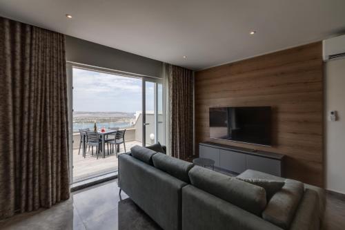a living room with a couch and a flat screen tv at Lovely Penthouse in Mellieha-seaview by Homely in Mellieħa
