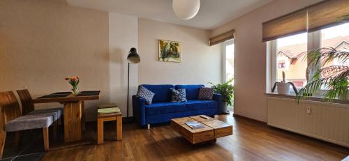 a living room with a blue couch and a table at Ferienwohnungen Altstadt in Plau am See