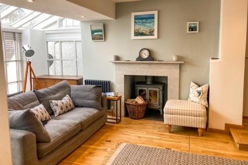 a living room with a couch and a fireplace at The Cottage , Newton Ferrers in Newton Ferrers