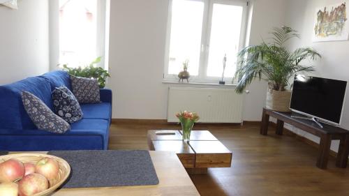 a living room with a blue couch and a table at Ferienwohnungen Altstadt in Plau am See