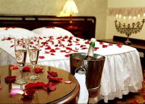 Habitación con cama con mesa y copas de vino en HOTEL MIRADOR DE LOS ANDES, en La Paz
