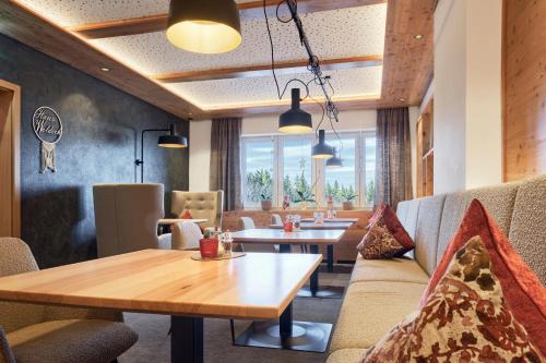 a restaurant with tables and couches and a table and chairs at Hunderesort Waldeck - 4 Sterne Urlaub mit Hund in Philippsreut