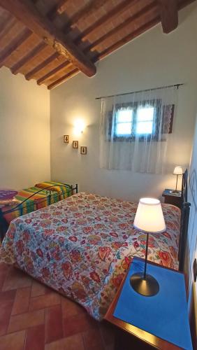 a bedroom with a bed and a table with a lamp at il Chiassetto Agriturismo No Kids in Cascina