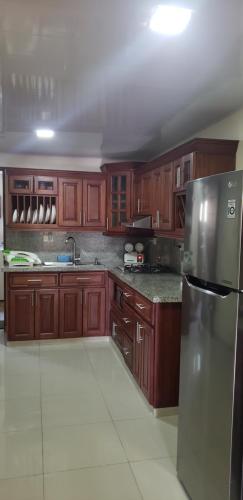 a kitchen with wooden cabinets and a stainless steel refrigerator at Jarabacoa Villa Anchorage in Jarabacoa