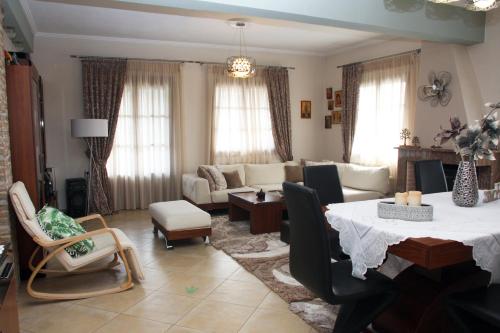 a living room with a table and a couch at IDEAL House skopelos in Skopelos Town