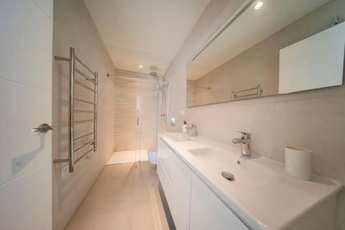 ein weißes Bad mit einem Waschbecken und einer Dusche in der Unterkunft Superior Penthouse 180º views, Jacuzzi Parking in Tarifa