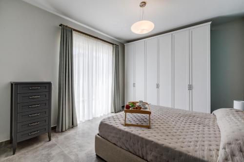 a bedroom with a large bed and a dresser at Lovely Penthouse in Mellieha-seaview by Homely in Mellieħa