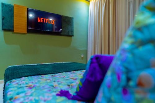 a bedroom with a bed with a tv on the wall at La casabella in Tangier