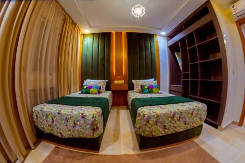 two beds in a room with curtains at La casabella in Tangier