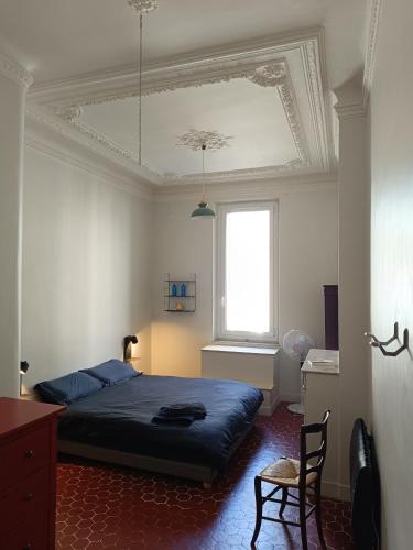une chambre avec un lit bleu et une fenêtre dans l'établissement Chambre d'hôtes 2 pers - Maison avec jardin et terrasse près de la Friche de la Belle de mai, à Marseille