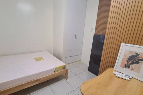 una pequeña habitación con una cama y una mesa en Muji Style Condo with Parking, en Manila