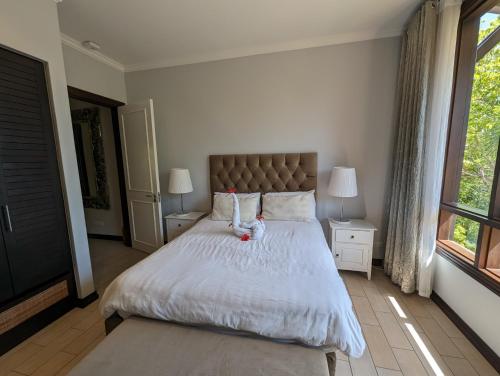 a bedroom with a bed with a teddy bear on it at Maison La Plage by Simply-Seychelles in Eden Island