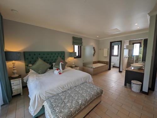 a bedroom with a large bed and a bathroom at Maison La Plage by Simply-Seychelles in Eden Island