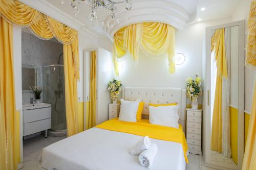 een witte slaapkamer met gele gordijnen en een bed bij Suite Soleil - Paris à 10 min - Apt d'exception in Deuil-la-Barre