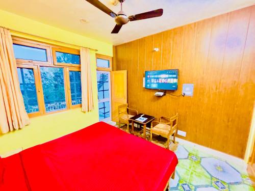 a bedroom with a red bed and a television at Grand view lodge and Restaurant Dharamshala - Partial Prepayment required to confirm booking in Dharamshala