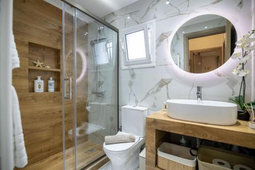 uma casa de banho com um WC, um lavatório e um espelho. em Dina Luxury Sea View House em Aiándion