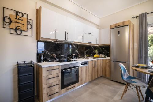 a kitchen with white cabinets and a table and chairs at Dina Luxury Sea View House in Aiándion