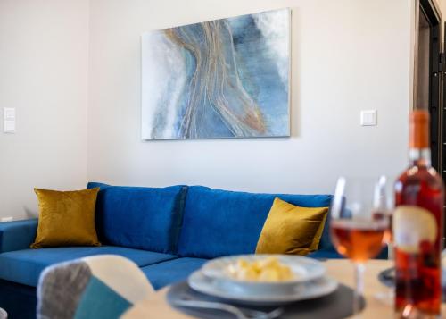 a blue couch with a plate of food on a table at Dina Luxury Sea View House in Aiándion