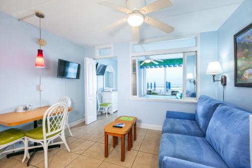 a living room with a blue couch and a table at Fantasy Island Resort, Daytona Beach Shores in Daytona Beach Shores