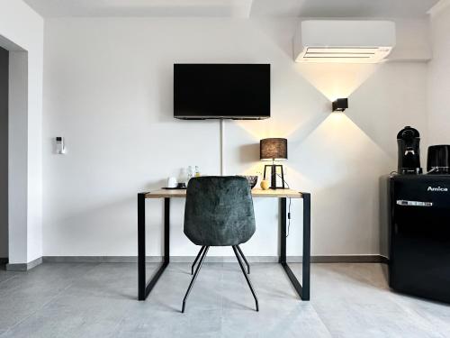 biurko z krzesłem i telewizor na ścianie w obiekcie Si-View Doppelzimmer mit Balkon Zimmer 1 w mieście Siegen
