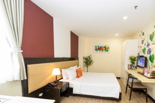 a hotel room with a bed and a desk at Asian Ruby Hotel & Spa - 122F Bui Thi Xuân Street in Ho Chi Minh City
