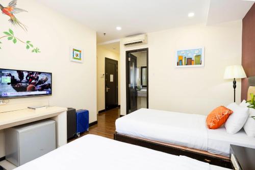 a hotel room with two beds and a tv at Asian Ruby Hotel & Spa - 122F Bui Thi Xuân Street in Ho Chi Minh City