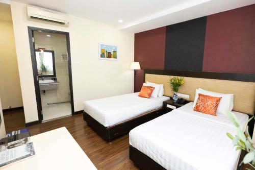 a hotel room with two beds and a mirror at Asian Ruby Hotel & Spa - 122F Bui Thi Xuân Street in Ho Chi Minh City