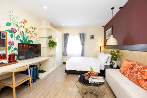 a hotel room with a bed and a couch at Asian Ruby Hotel & Spa - 122F Bui Thi Xuân Street in Ho Chi Minh City