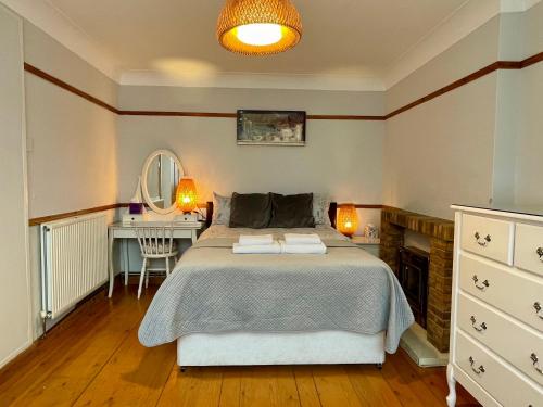 a bedroom with a bed and a desk and a mirror at Somers House - pet friendly & parking in Portsmouth
