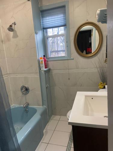 a bathroom with a blue tub and a sink at Elegantly English Catskills in Liberty