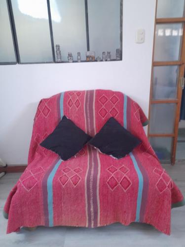 - un lit rose avec une couette rouge et une archet dans l'établissement Apartamento sn, à Puno
